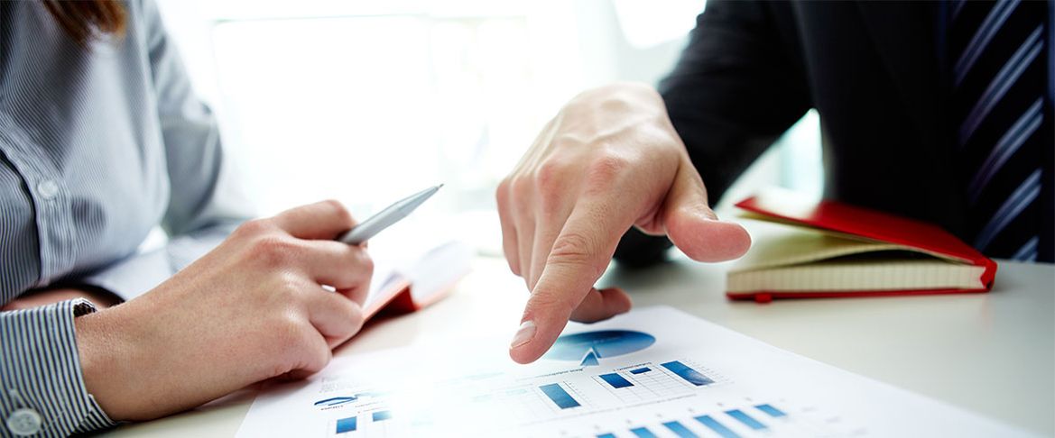 Two colleagues reviewing financial charts and reports together