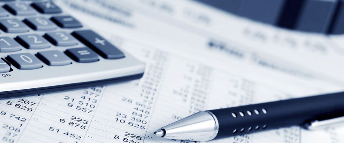 A calculator and pen resting on printed financial statements
